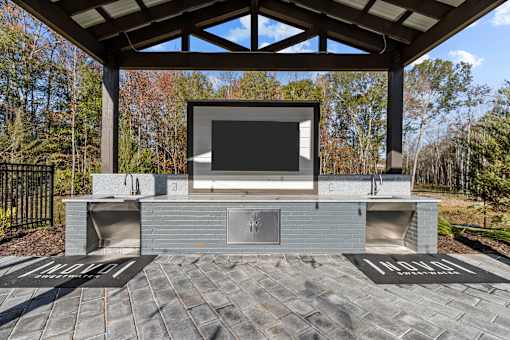 A modern outdoor entertainment area with a television and seating.