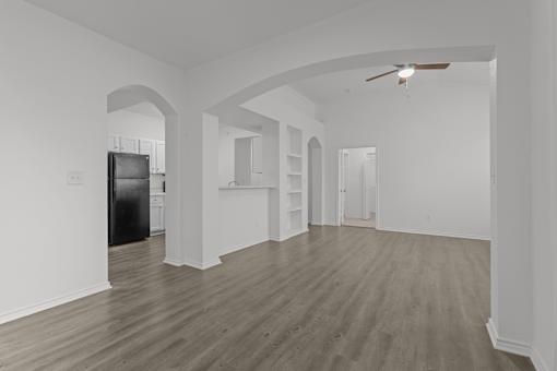 A spacious room with wooden flooring and white walls.