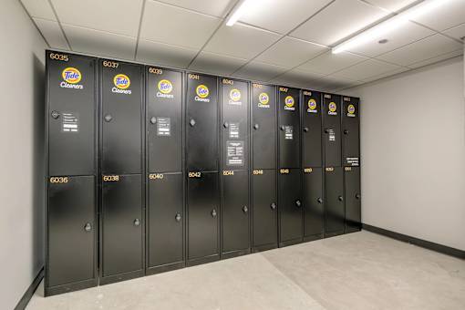 A row of black lockers with yellow and blue labels for Fold Cleaners.