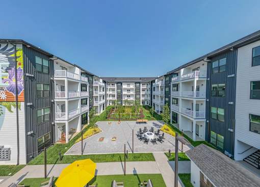 A modern apartment complex with a central courtyard and playground.