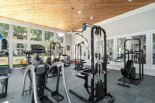 A gym with a variety of equipment including treadmills, stationary bikes, and weight machines.