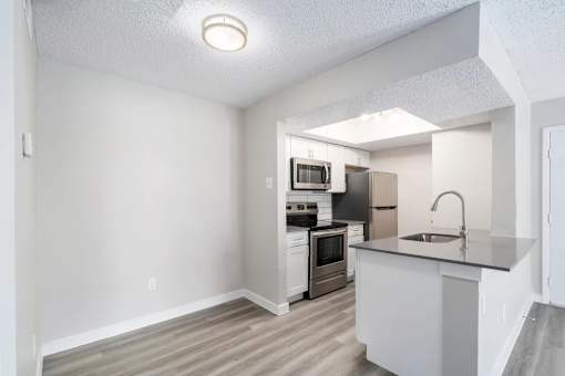 A kitchen with white cabinets and a sink.