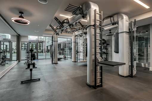 A gym with a variety of equipment including treadmills, weights, and exercise machines.