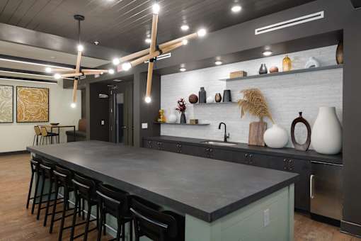A modern kitchen with a long island and bar stools.