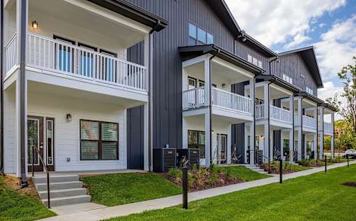 A row of modern houses with balconies and white railings.