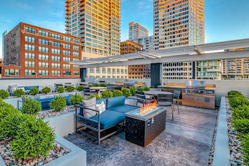 A rooftop patio with a fire pit and seating area.
