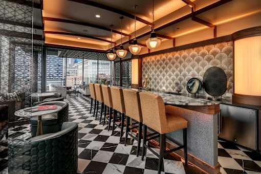 A restaurant with black and white checkered flooring and wooden chairs.