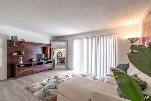 a living room with a couch and a tv and a large window