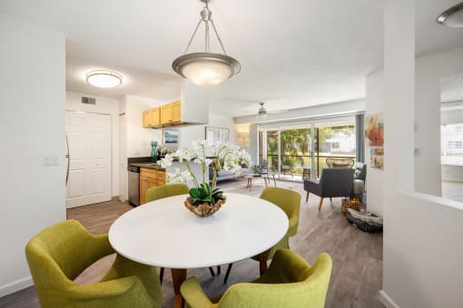 a dining room with a white table and green chairs