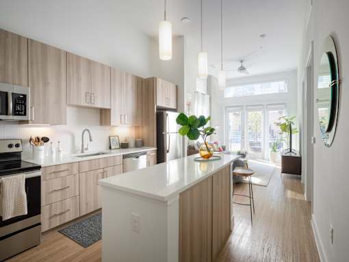 A modern kitchen with wooden cabinets and a white island.