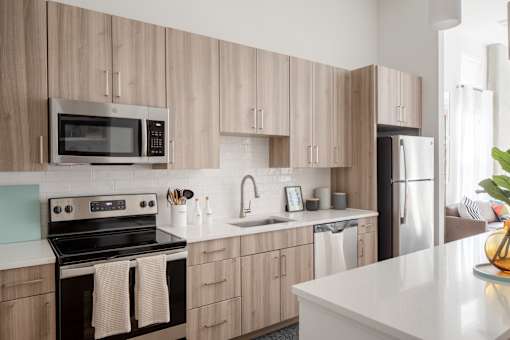 A kitchen with wooden cabinets and a black stove top oven.