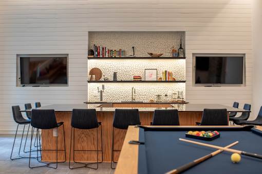 A pool table with a cue and balls in the middle of it.