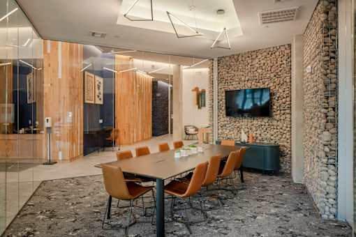 A conference room with a stone wall and a long table with chairs.