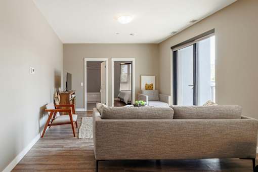 A living room with a grey couch and a wooden chair.