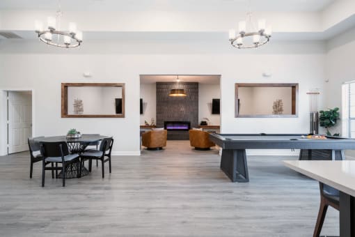a game room with a ping pong table and chairs