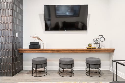a room with a television and three stools