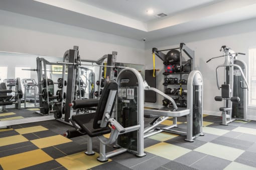 a spacious fitness room with weights and cardio equipment