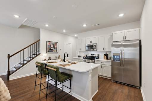 A kitchen with a white counter top and a stainless steel refrigerator.