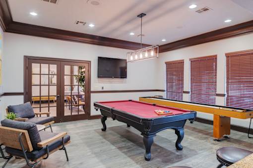 A pool table in a room with a television and a chair.