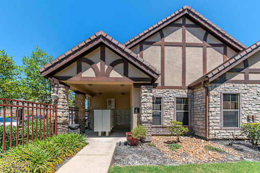 A house with a brown roof and a stone wall.