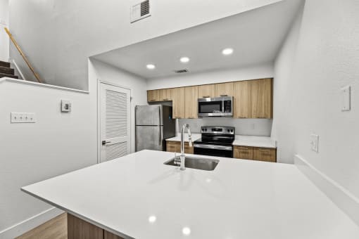 a kitchen with a white counter top and a sink
