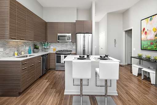 A modern kitchen with white and brown cabinets, a white countertop, and a painting on the wall.