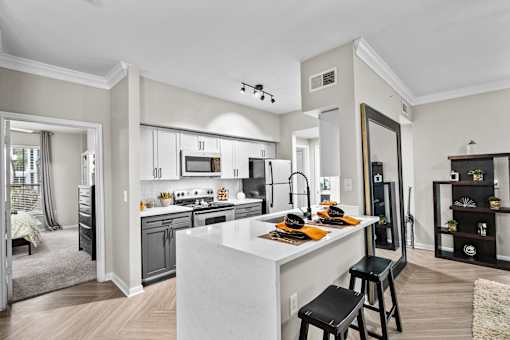 A modern kitchen with a large island and stools.