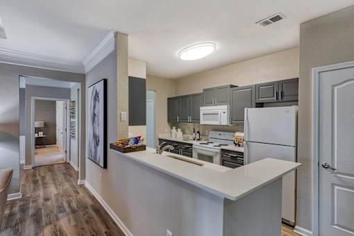 A kitchen with a white countertop and stainless steel appliances.