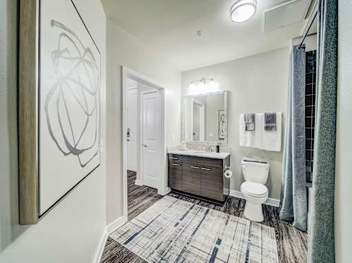 A bathroom with a toilet, sink, and mirror.