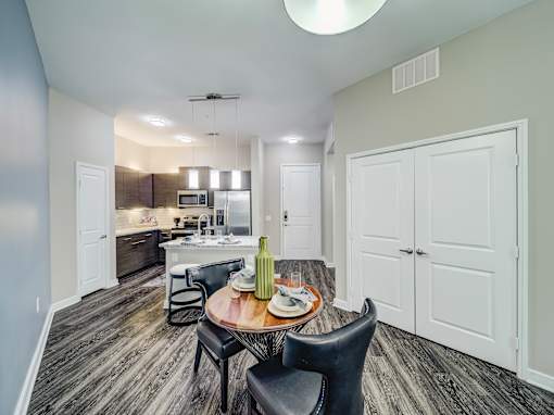 A modern kitchen with a dining table set for two.