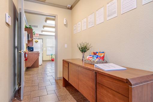 A hallway with a wooden desk and a wall of papers.