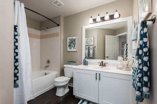 A white bathroom with a toilet, sink, and shower.