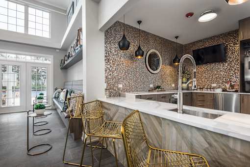 A kitchen with a marble countertop and a wall of windows.