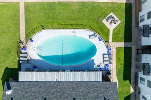 An outdoor swimming pool surrounded by a black fence.