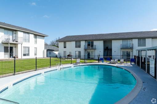 A swimming pool in front of apartment buildings.