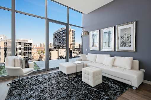 A living room with a white sofa and a black rug.