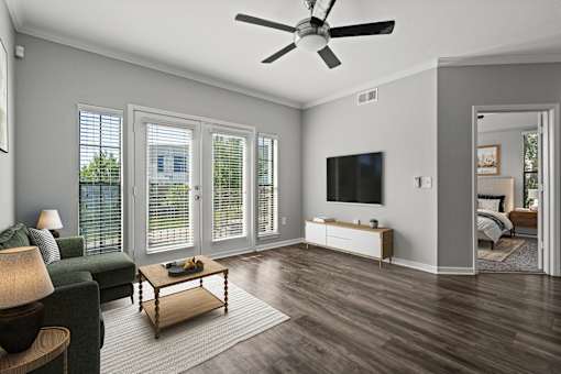 A living room with a ceiling fan and a television.