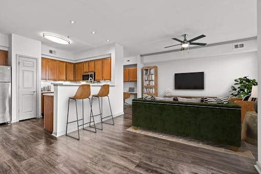 A modern kitchen with wooden cabinets and a green couch.
