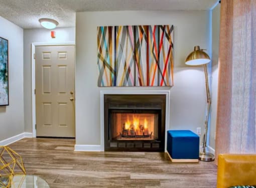 a living room with a fireplace and a painting on the wall