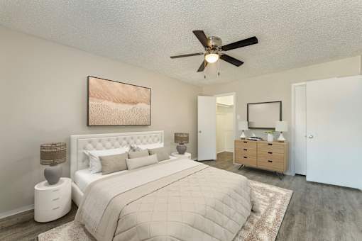 A bedroom with a large bed and a ceiling fan.