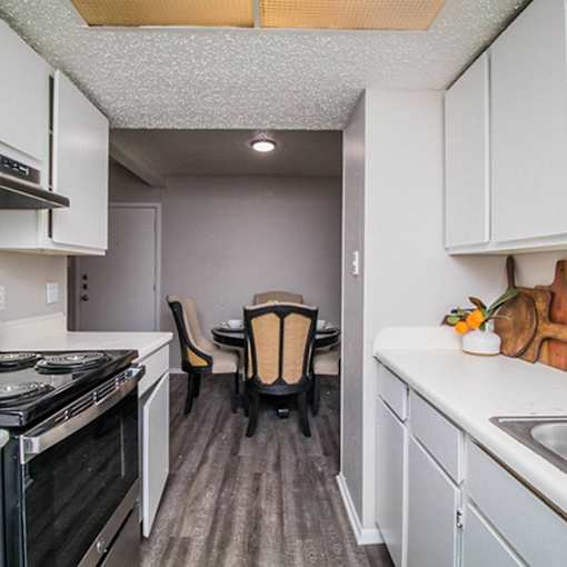 A kitchen with white cabinets and a black stove top oven.