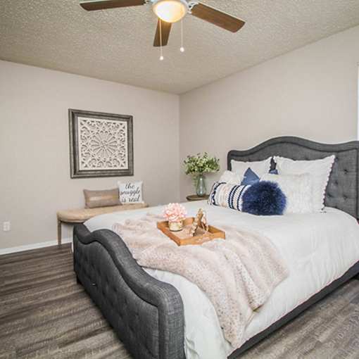 A bedroom with a large bed and a ceiling fan.