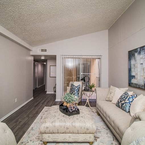 A living room with a couch, chair, and a table with a plant on it.