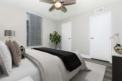 A bedroom with a large bed and a ceiling fan.