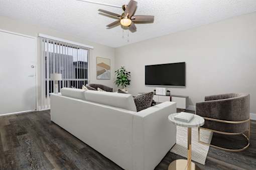 A living room with a white couch and a ceiling fan.