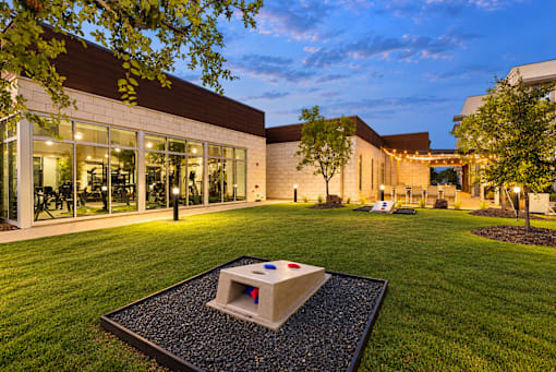 A modern building with a large glass window and a tree in front of it.