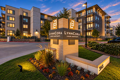 A LynnCora sign is in front of a building with a garden in front of it.