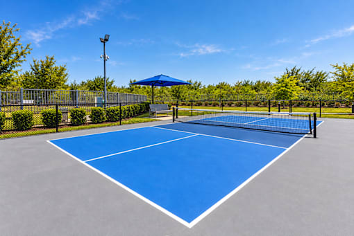 A blue tennis court with white lines and a white canopy.
