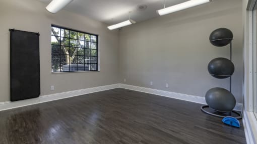 an empty room with exercise balls and a window