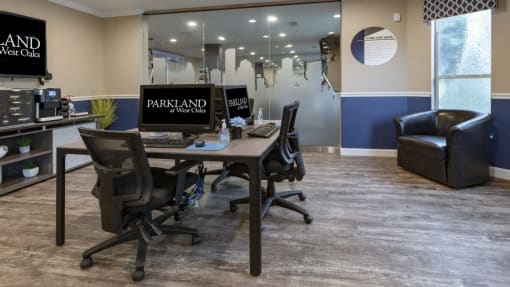 a desk with two computers and a chair in an office